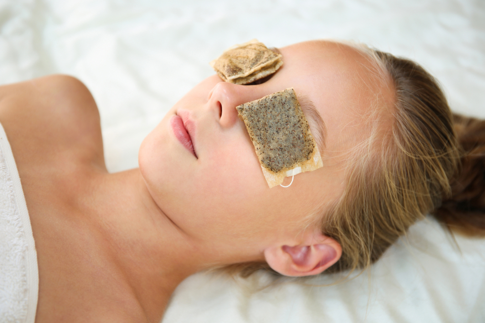 Woman using tea bags over her eyes