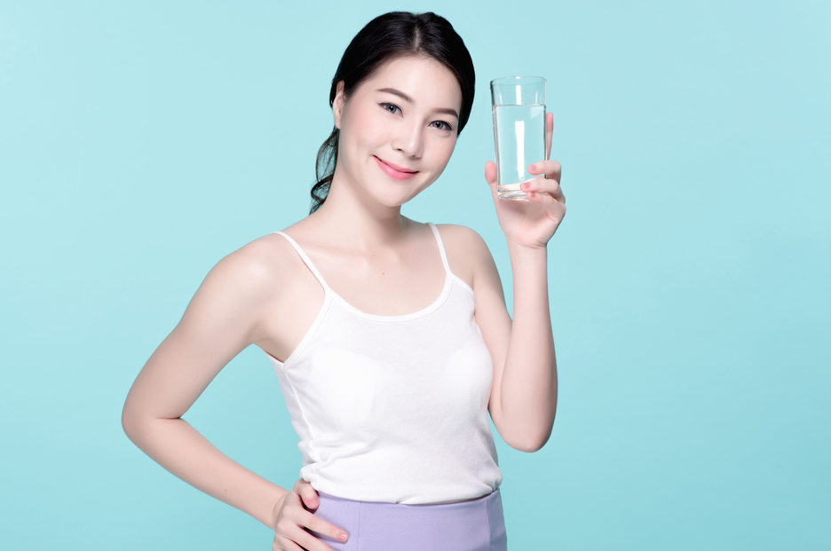 Healthy asian young beautiful woman drinking water, beauty face natural makeup, isolated over blue background.