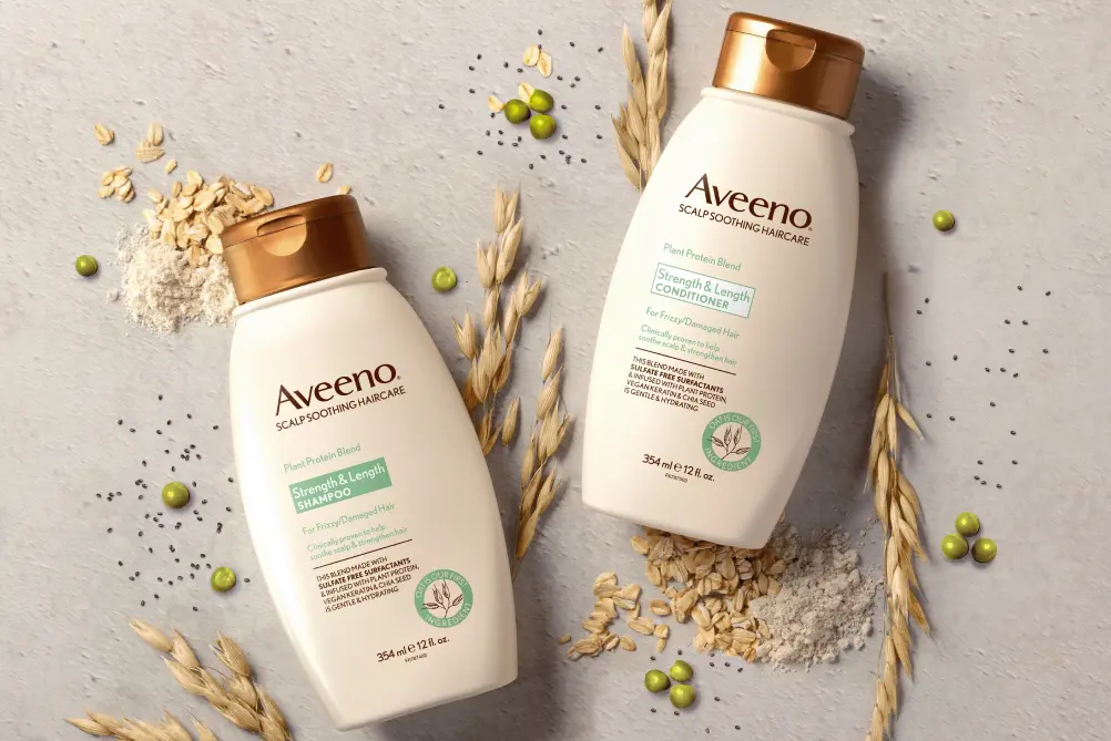 AveenoÂ® Strength & Length haircare set displayed with its nourishing ingredients for frizz control