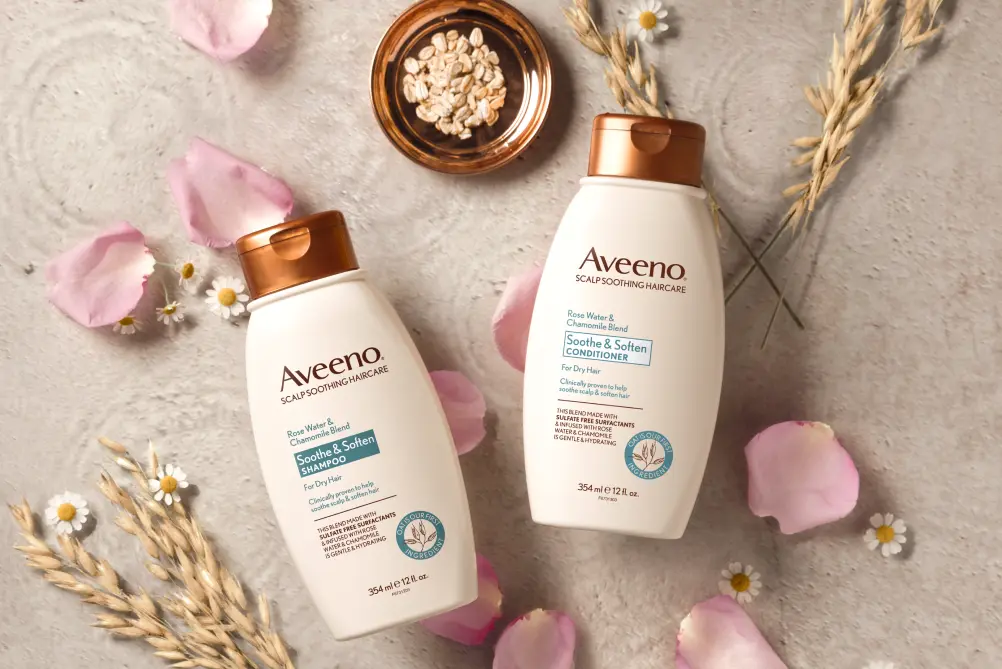 AveenoÂ® Soothe & Soften Shampoo and Conditioner set displayed with its nourishing ingredients to soften hair