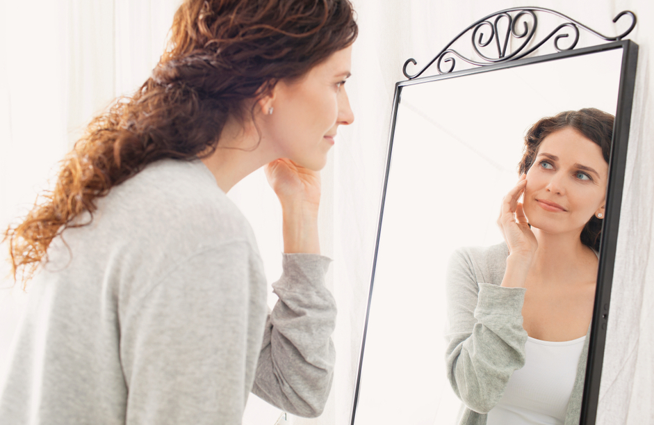 Woman looking at herself in a mirror.