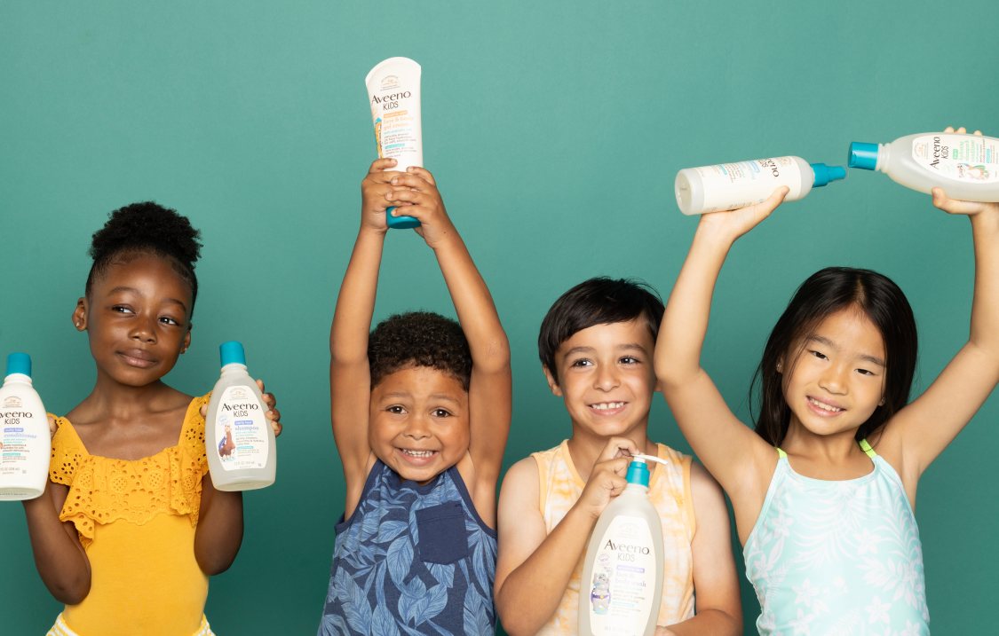 a group of children are holding Aveeno Kids products