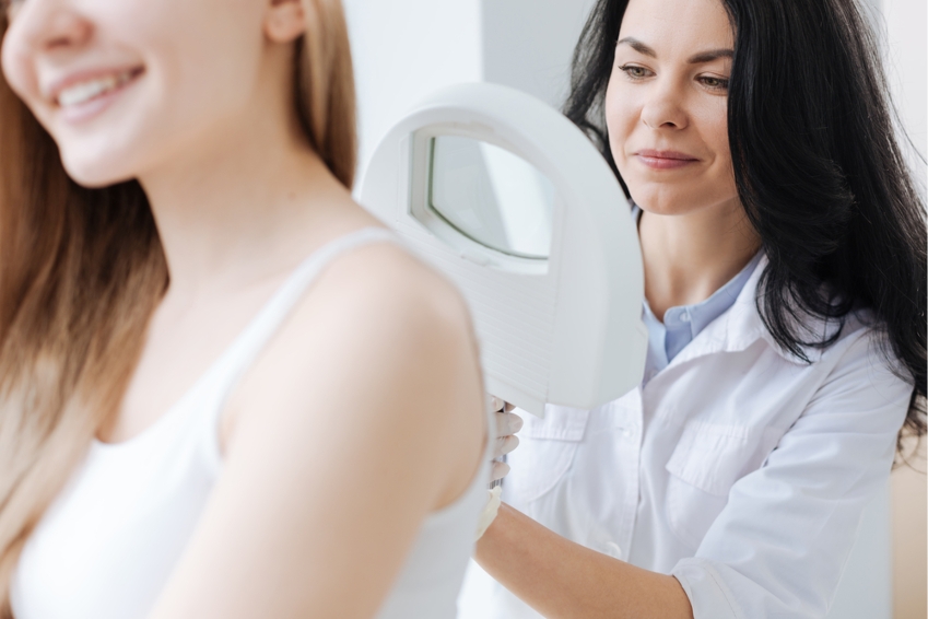 Dermatóloga mirando la espalda de una mujer