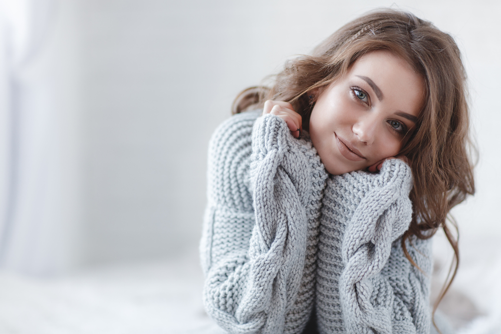 Woman with dry skin wearing a sweater in winter.