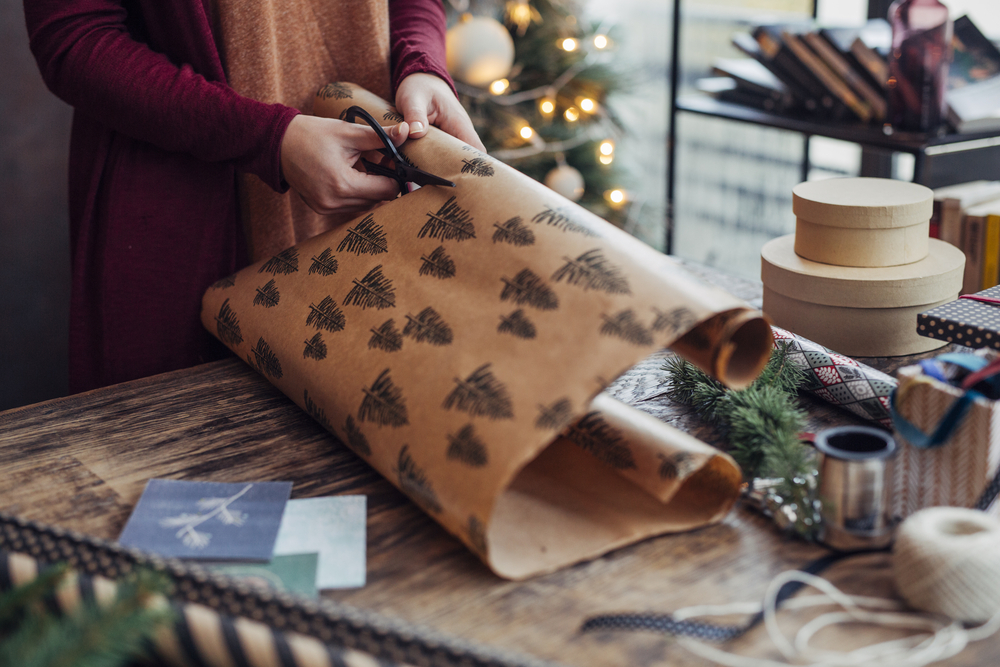 Woman wrapping and decorating Christmas present.